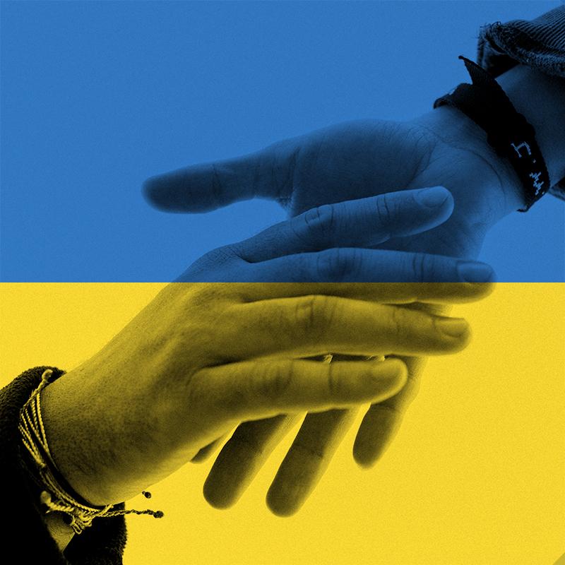 Zwei Hände geben sich die Hand, darüber liegt die Flagge der Ukraine in blau und gelb