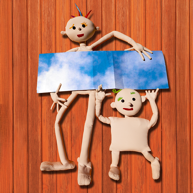 Sujetbild Theater: zwei Puppen halten ein Bild vom Himmel