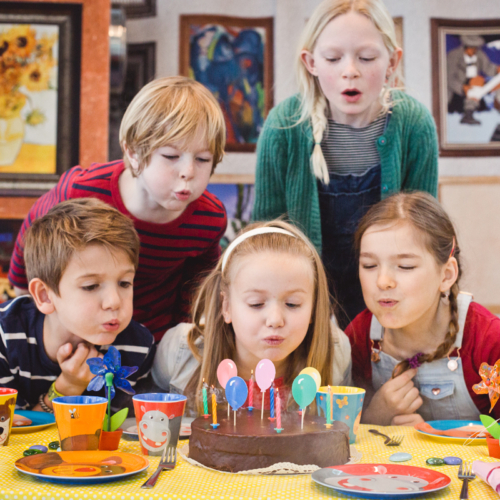 Kinder blasen Kerzen auf einer Torte aus