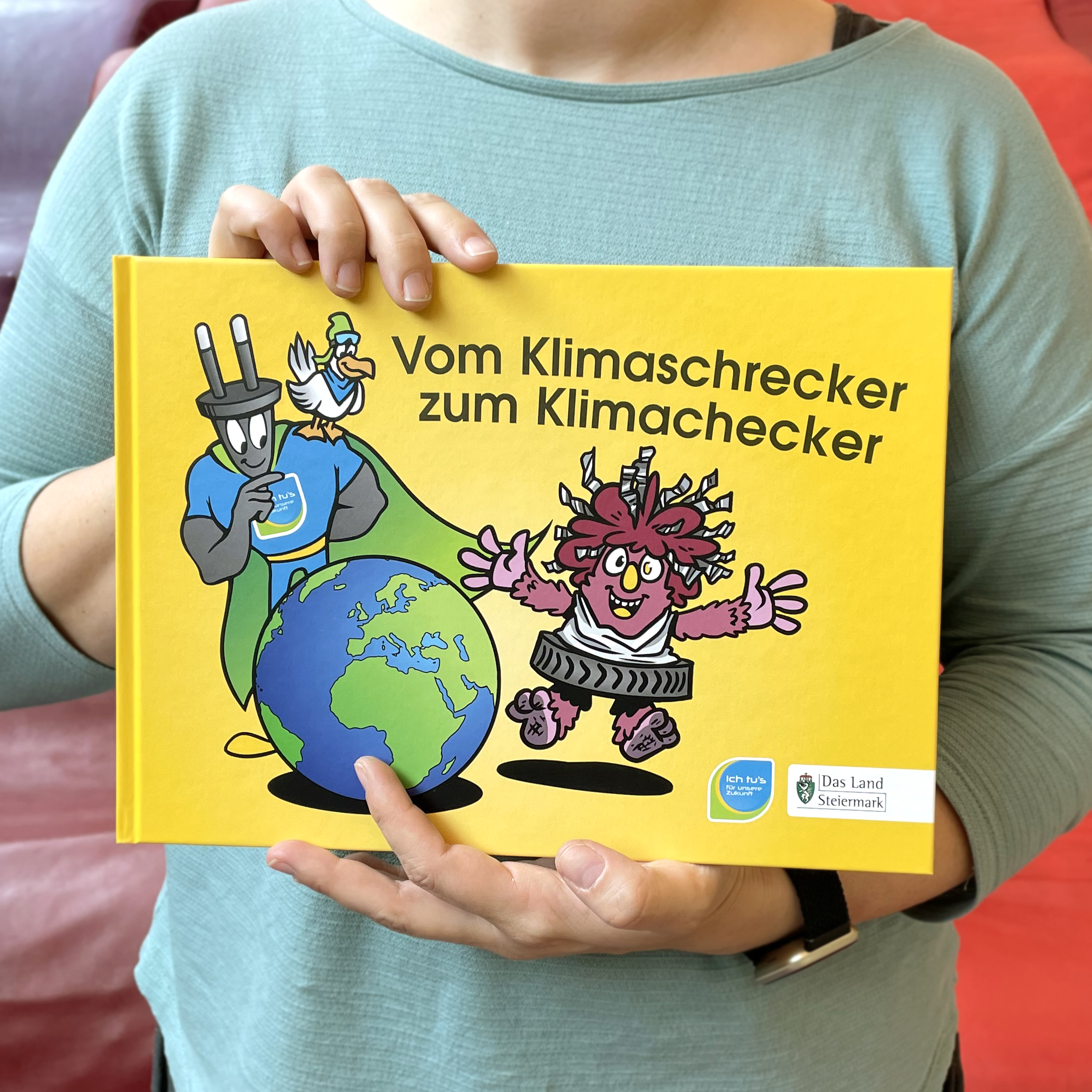 Frau hält Buch "Vom Klimaschrecker zum Klimachecker" in der Hand
