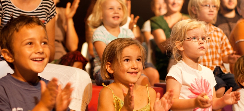 Kinder-Publikum schaut auf Theaterbühne