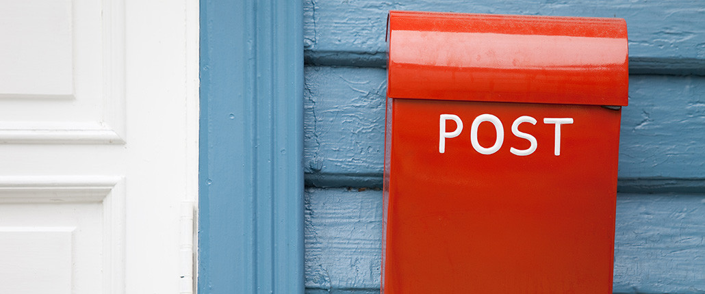 roter Briefkasten an blauer Holzwand