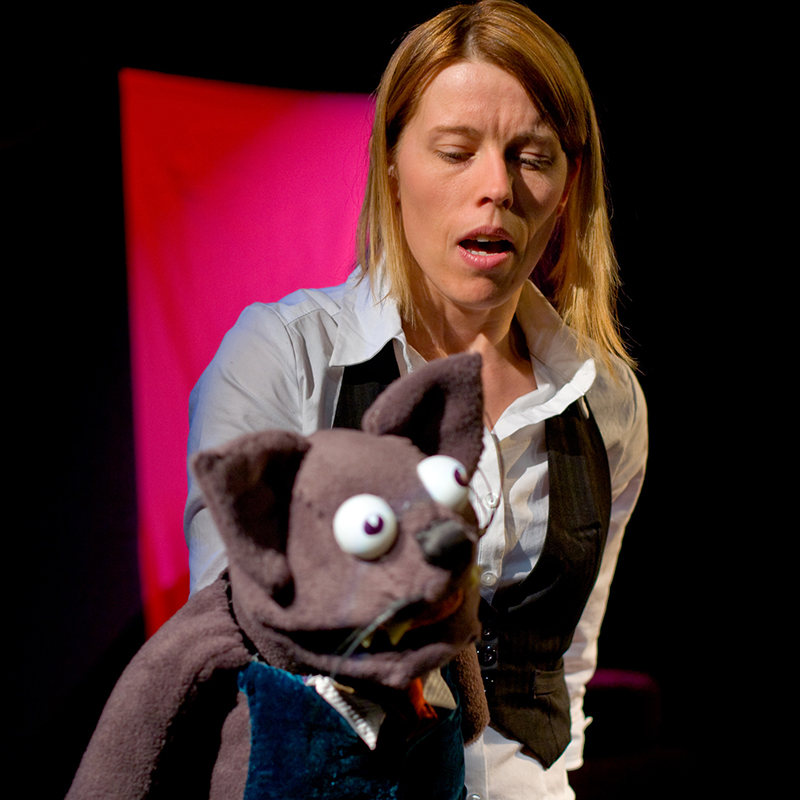 Schauspielerin mit Katzen-Handpuppe auf der Theaterbühne