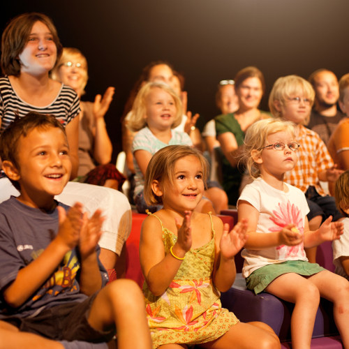 Publikum aus Kindern schauen auf Theaterbühne