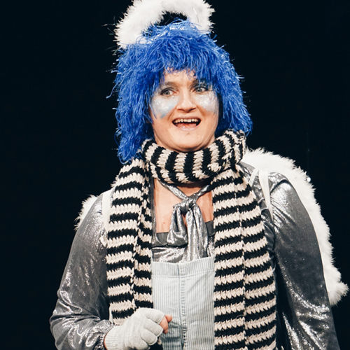 Schauspielerin als Engel verkleidet mit blauen Haaren und gestreiftem Schal