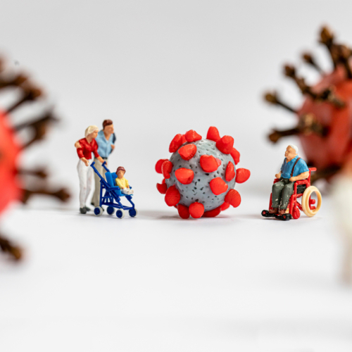 Miniaturfiguren schauen ängstlich auf Corona-Virus